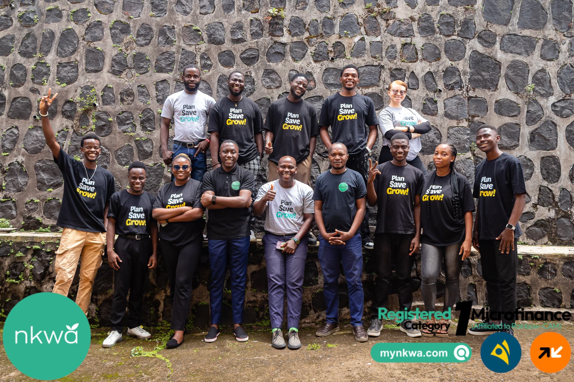 Nkwa team posing against a stone wall